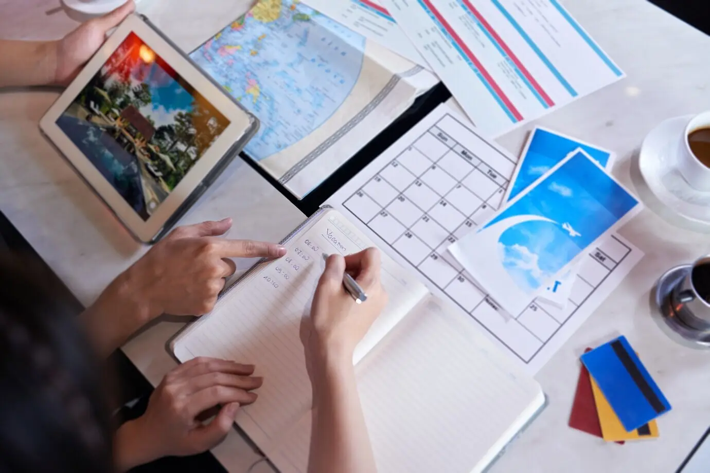 Overhead view of unrecognizable people planning a vacation trip