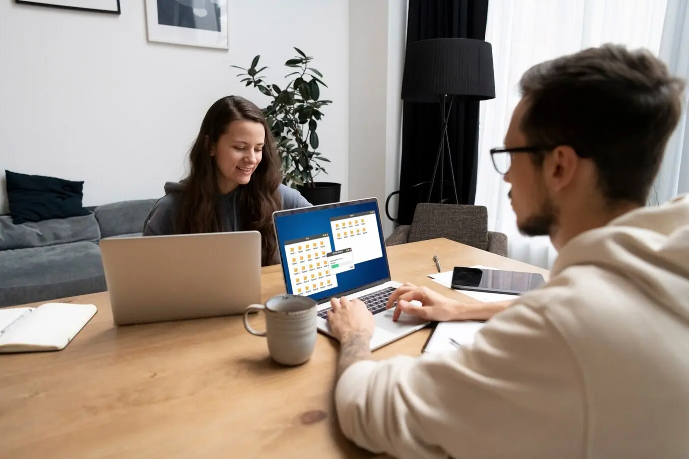 A couple collaborating at a desk while working from home.